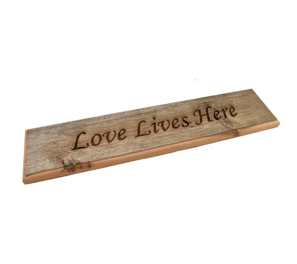 Barnwood door topper sign that reads, "Love Lives Here".