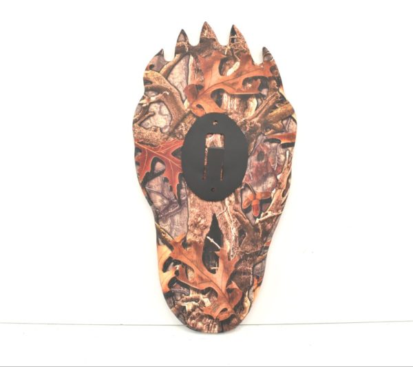 Bear paw plaque with camouflage design printed on it.