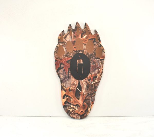 Bear paw plaque with camouflage design printed on it.