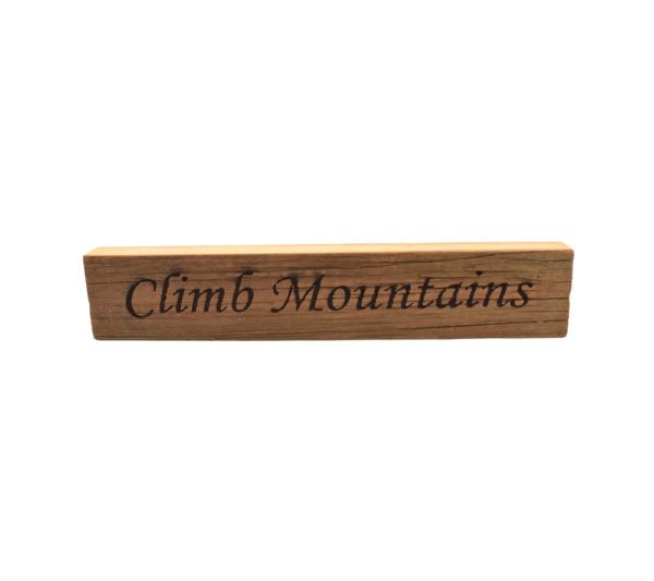 Reclaimed barn wood block sign that reads, "Climb Mountains".