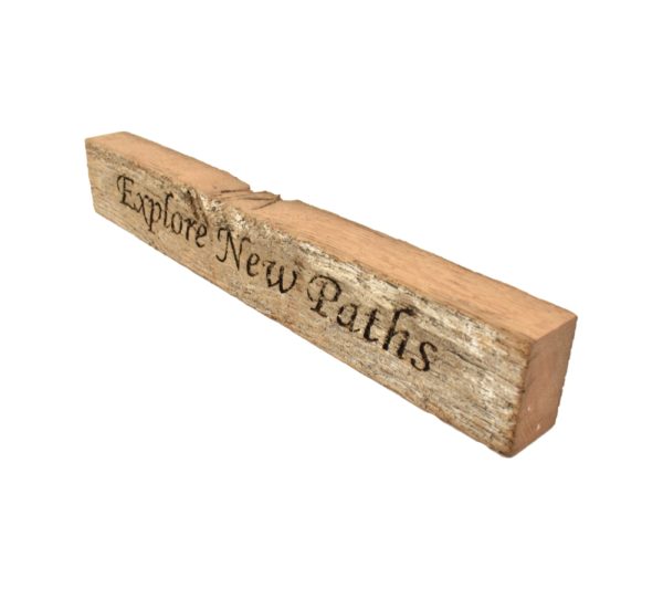 Reclaimed barn wood block sign that reads, "Explore New Paths".