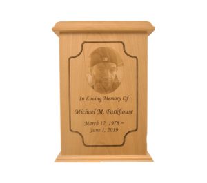 Tall rectangular urn with an engraved picture.