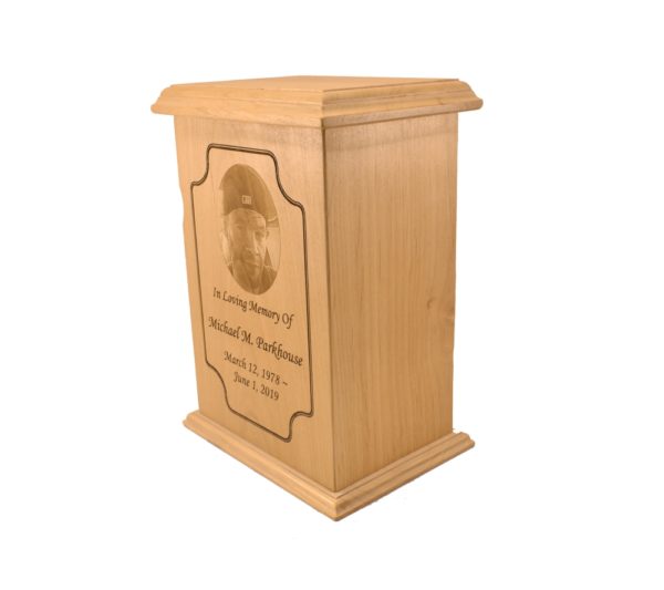 Tall rectangular urn with an engraved picture.