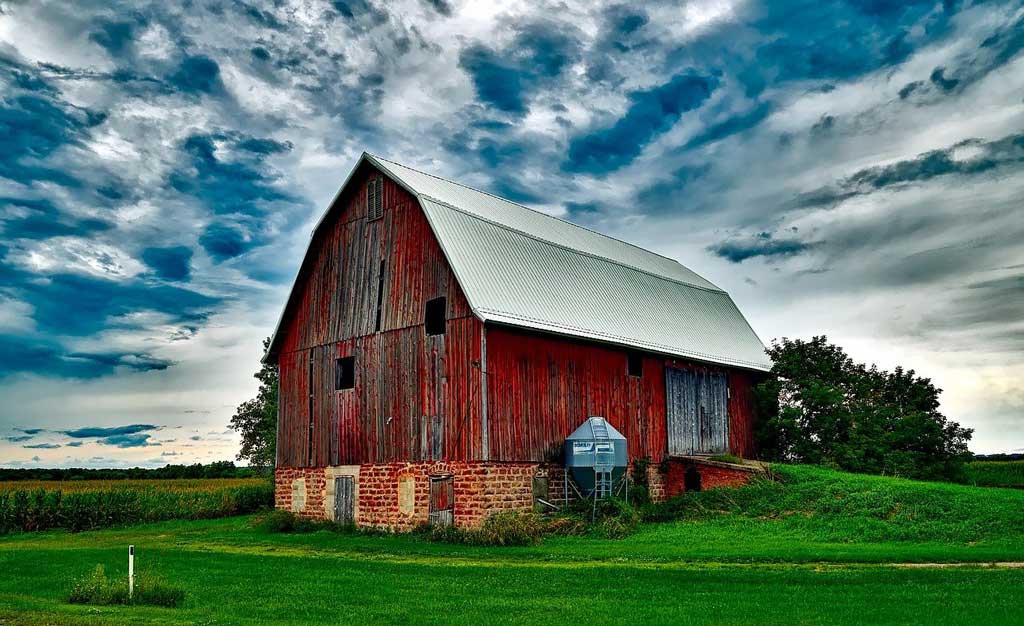 red barn against a blue sky with clouds