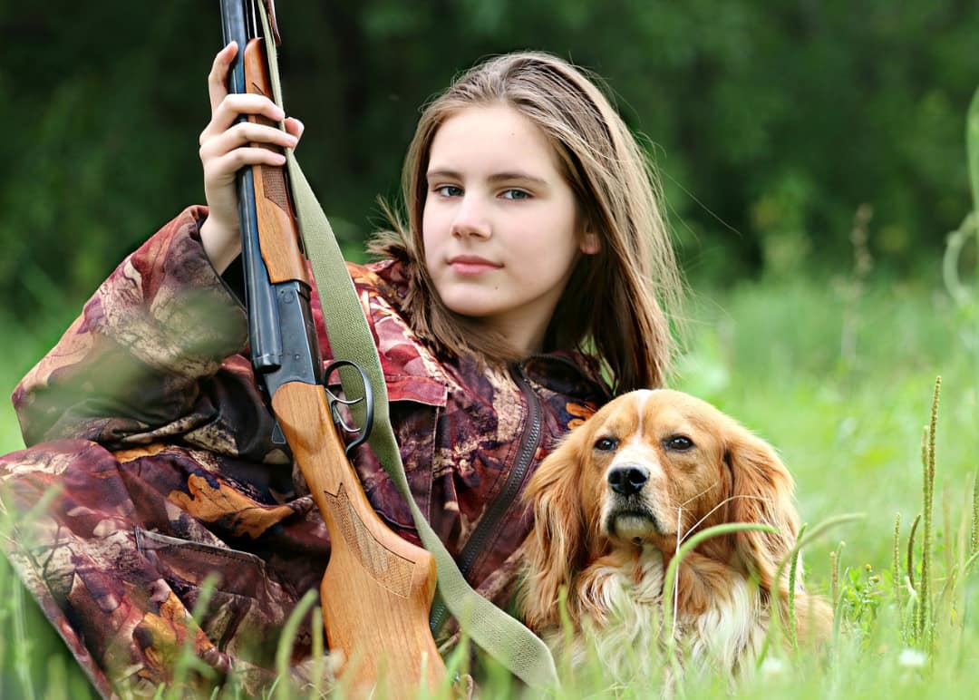 A girl with a hunting rifle with a gun stock engraving pattern.