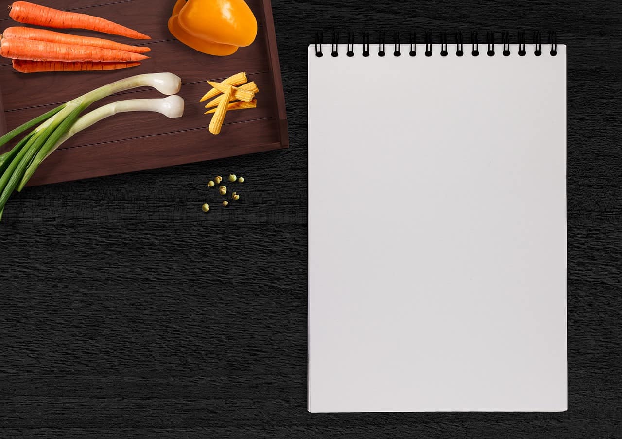 A notepad near vegetables in a kitchen