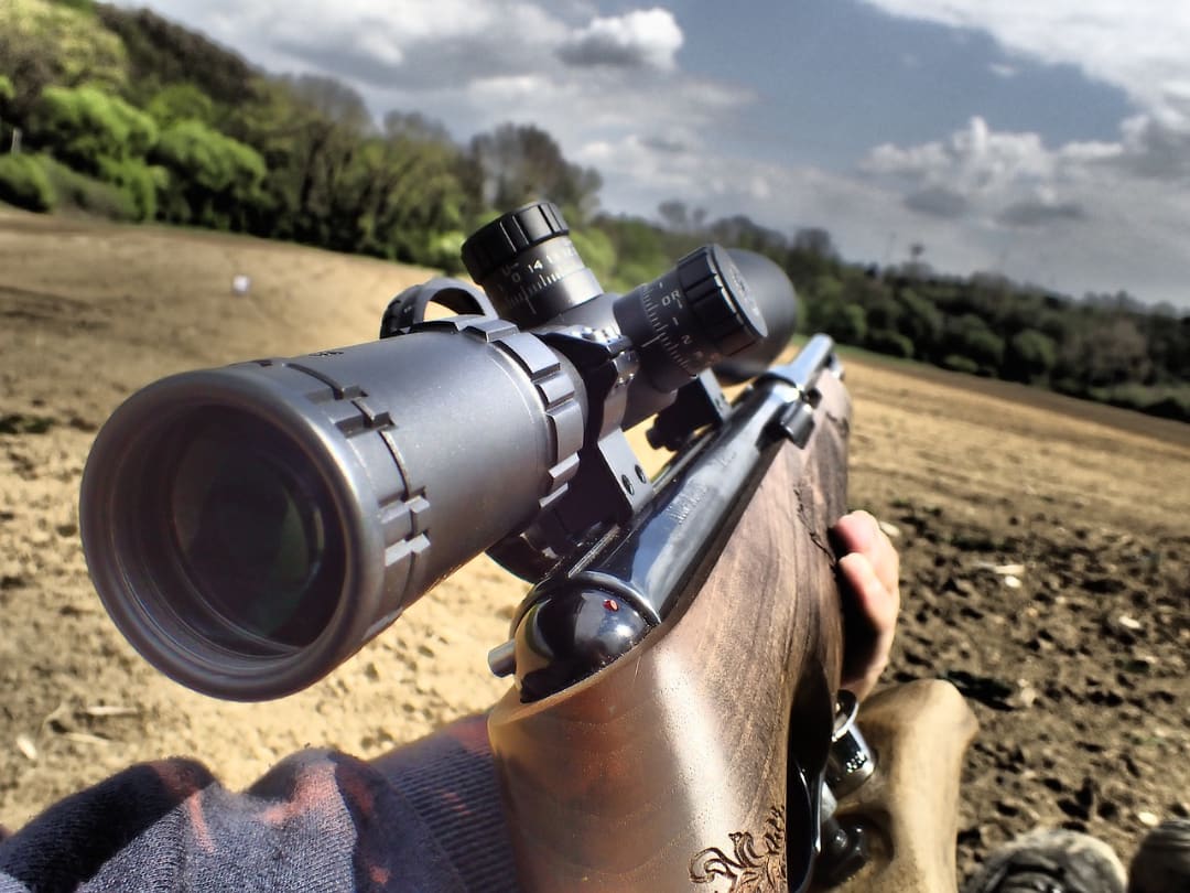 Person holding and aiming a rifle